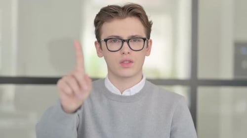Young Adult Gesturing No with Finger Raised