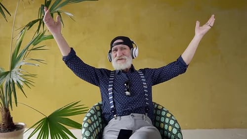 Senior Man Enjoying Music in Chair Indoors