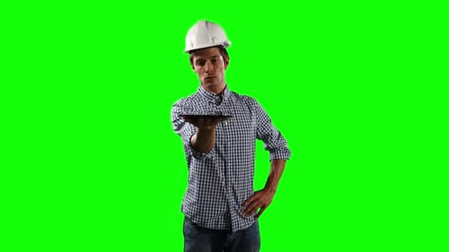 Front view of site worker holding a digital tablet with green screen
