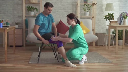 Physical Therapist Adjusting Knee Brace on Man's Leg