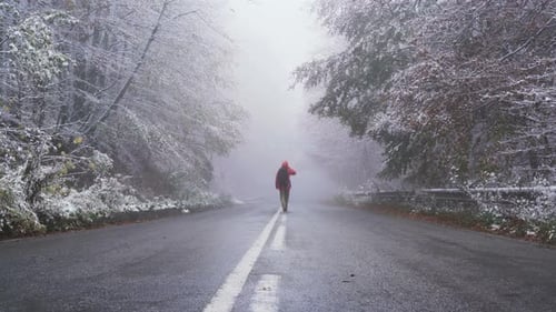 Happy Man Walking on Frozen Asphalt Road Carrying His Backpack in Winter Conditions