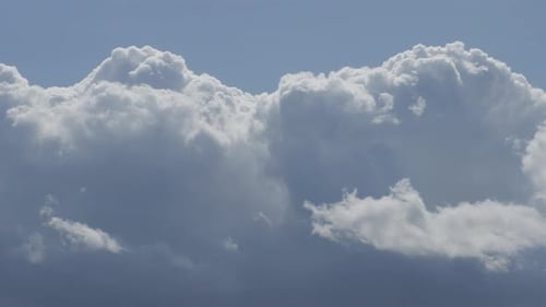Wolken bewegen sich gegen den blauen Himmel