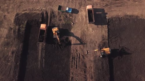 Excavators Loading Soil Into Trucks From Above