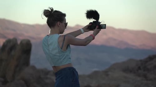 Young Adult Woman Filming in Desert Landscape