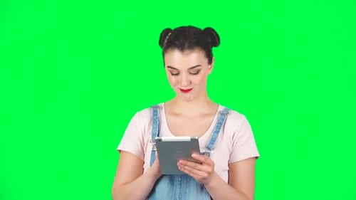 Young Smiling Woman Texting on Her Tablet Computer on Green Screen, Slow Motion