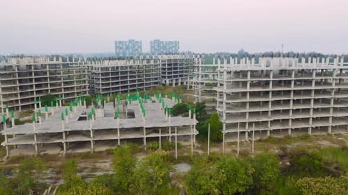 Aerial top view of abandoned apartment or hotel under construction site with structure.