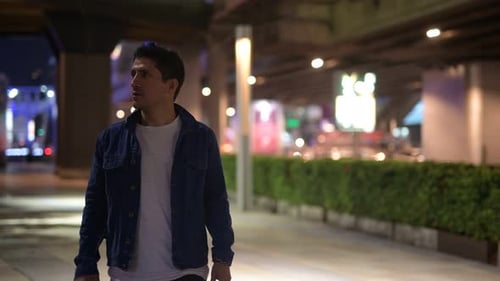 Hispanic Man Thinking While Exploring the City Streets at Night