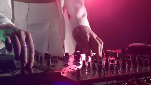 Dj Hands on Stylish Equipment Deck, Tanzen und Spielen, Nahaufnahme, rosa Hintergrundbeleuchtung, Zeitlupe