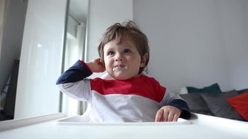 Adorable Child Sits In High Chair Indoors