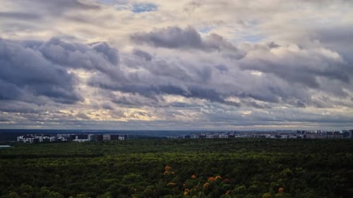 Dark rain clouds over the autumn forest, timelapse