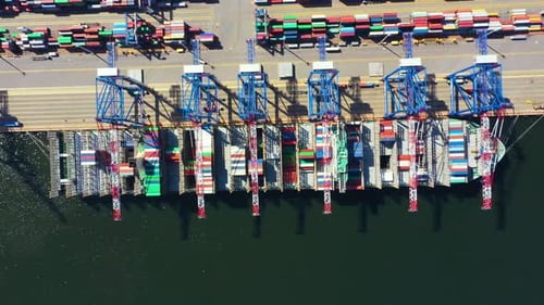 Container ship in export and import business and logistics. Shipping cargo to harbor by crane. Water