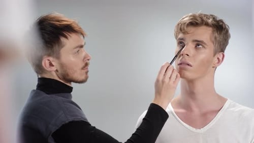 Makeup Artist Applying Makeup To Male Model