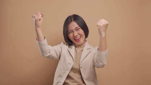 Cheerful Woman Celebrating Success With Arms Raised