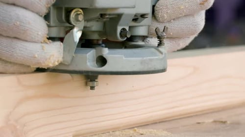 Hands Using Router on Wood Plank Close Up