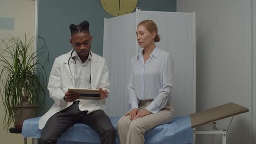 Doctor Consults with Patient Using Tablet in Office