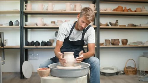 Man Shaping Clay on Pottery Wheel in Studio