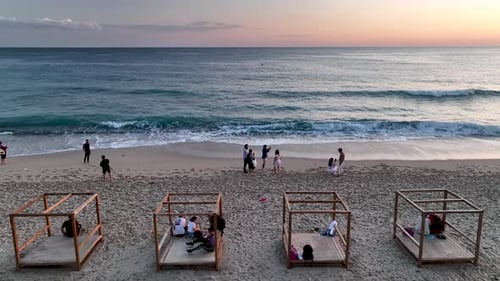People sit on the beach and watch the sunset