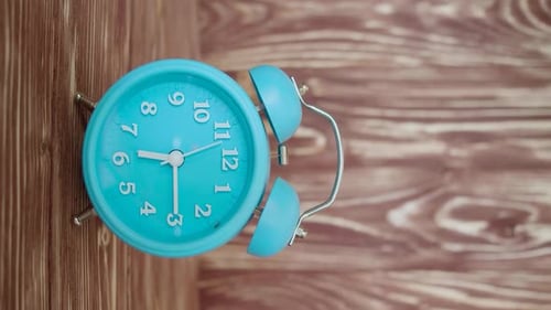 Vertical Video with Sound White Alarm Clock on a Wooden Background Rings at 615 AM