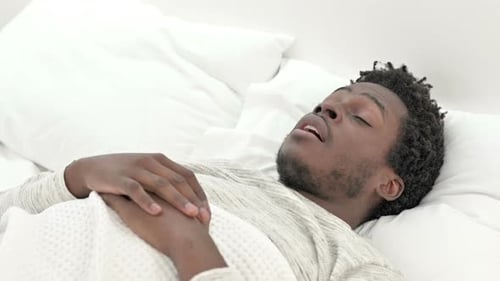 Young Adult Waking Up, Stretching in Bed