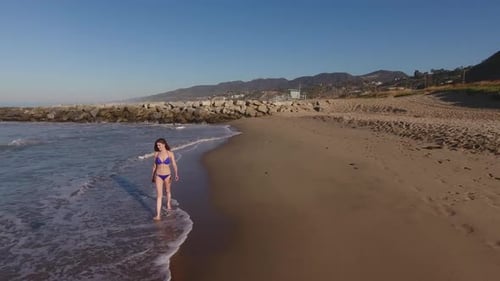 Woman Walking On The Beach