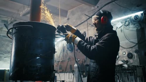 Man Grinding Metal Sparks Flying Indoors