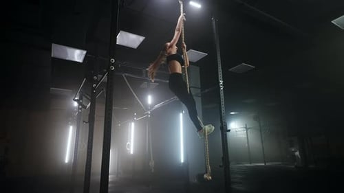 Woman is Climbing Rope in Fitness Center Physical Exercise Developing Endurance and Power of Arms