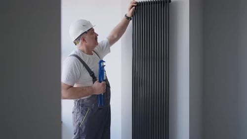 A Man Plumber Checks the Batteries and Heating System