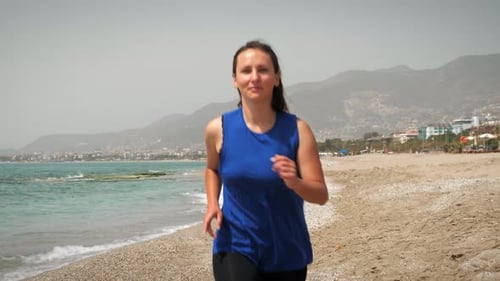 Smiling happy woman running on beach at sunny day