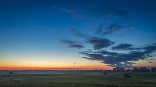 Wunderschöner Sonnenaufgang über einem Feld mit einer Windmühle, Zeitraffer, 4K