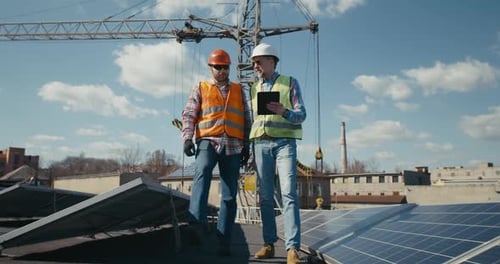 Ingeniero y técnico discutiendo entre paneles solares