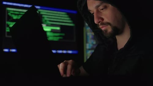 Man Using Computer in Dark Room at Night