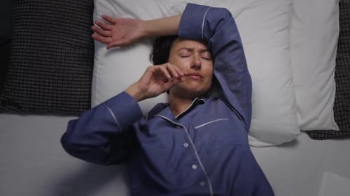 Woman Lying in Bed Looks Distressed