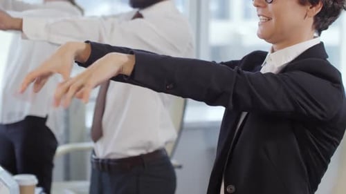 Office Employees Stretching Arms During Break at Work