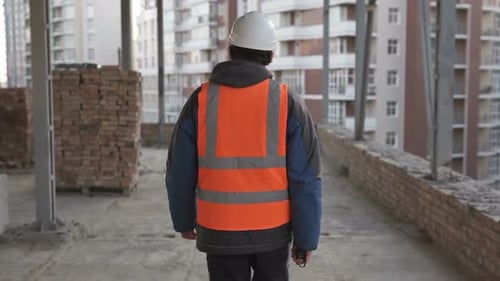 Construction Engineer Walks on the Roof of a Building Which is Under Reconstruction
