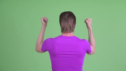 Rear View of Happy Young Man with Fists Raised