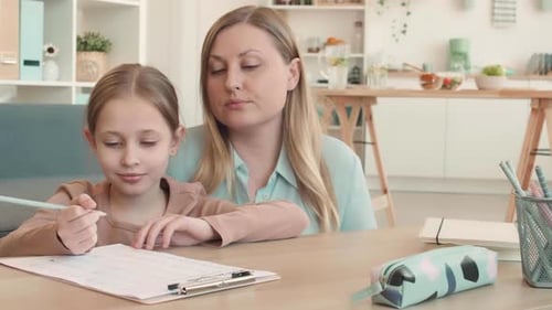 Child Doing Homework with Assistance From Woman