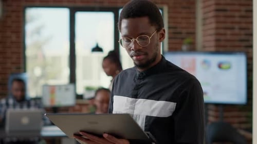 Portrait of African American Man Analyzing Statistics on Laptop