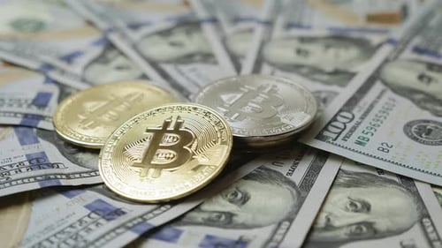 Münzen von Bitcoin BTC vor Dollar-Hintergrund