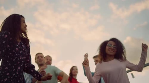 Young Adults Dancing at a Sunset Rooftop Party