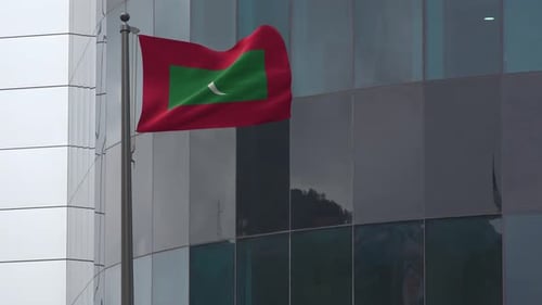 Maldives Flag Waving on Flagpole in Front of Corporate Building