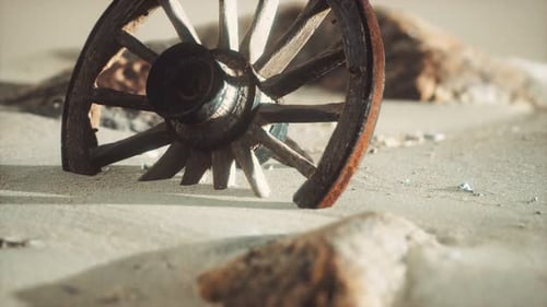 Old Broken Wooden Wheel Half Buried in Desert Sand