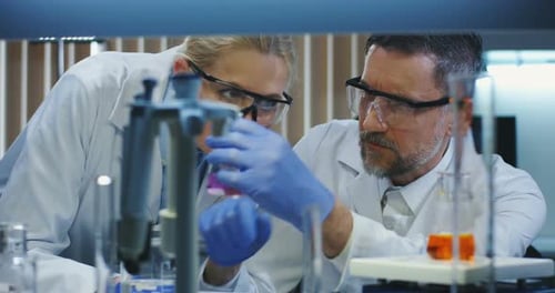 Scientists Examining Purple Liquid in Lab