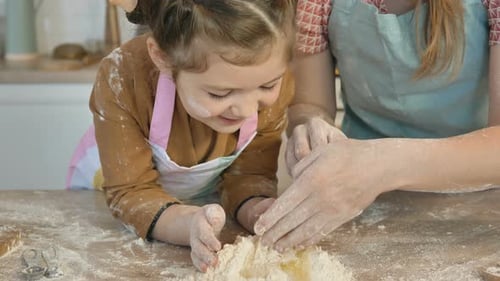 Mother Helps Daughter Mix Egg with Flour To Make Pie Dough