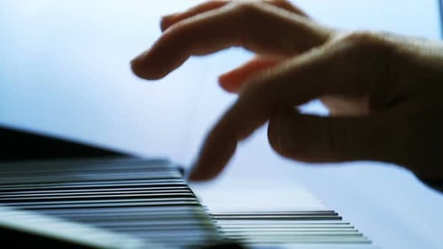 Close-up of hands playing piano