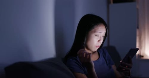 Woman Rubbing Eyes While Looking at Phone at Night