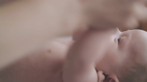 Infant on Back, Adult Cares for Baby in Home