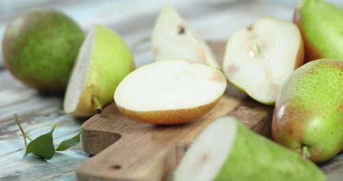 Whole and Slices Pear on the Cutting Board Slowly Rotate.