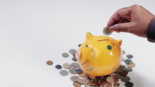 Hand Drops A Euro In A Piggy Bank