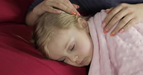 Young Mother Taking Care of Her Little Baby Girl While She Sleep. Girl on Bed