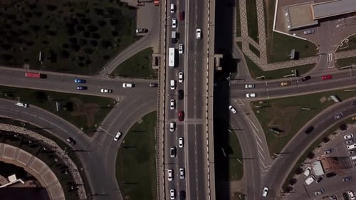 Drone's Eye View - Overhead Top Down View Of Traffic Driving Over A Modern Bridge